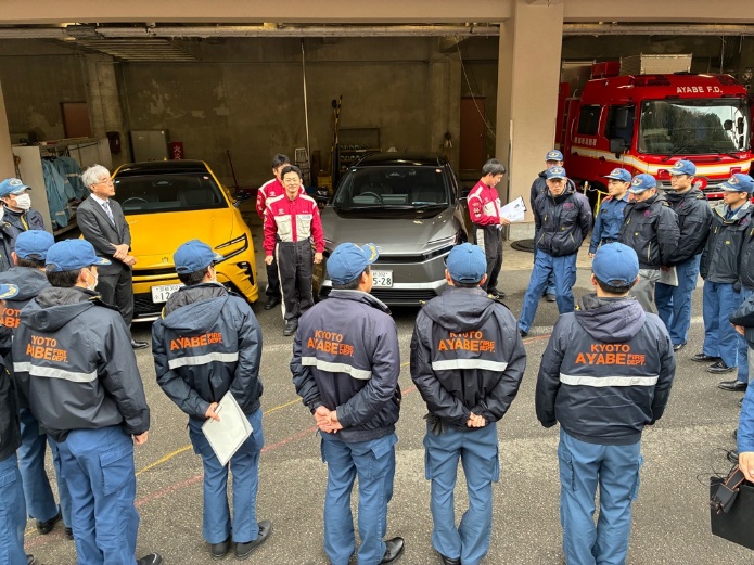 屋外で電動車の種類について説明を受ける様子を撮影したもの