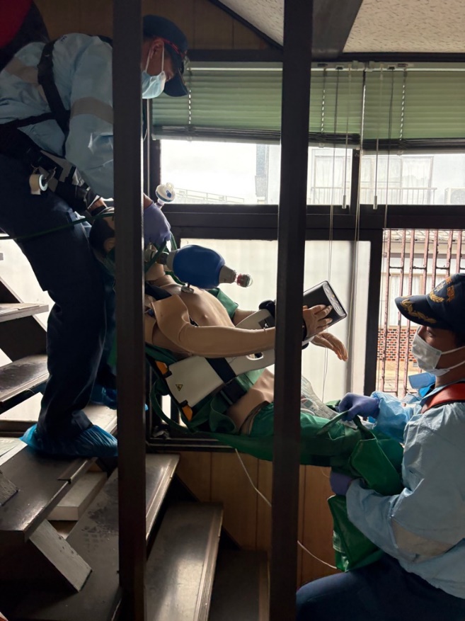 救命処置を施した傷病者を救急車へ向け搬送する訓練を撮影した写真